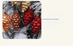 Detail von Tannenzapfen-Weihnachtsschmuck mit Metall-Finish auf verschneiten Zweigen