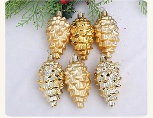 Detail von 6 goldenen Zapfen-Weihnachtsanhängern in matt und glänzend auf Schnee-Hintergrund