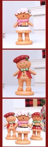 Detail of three resin gingerbread figurines in festive outfits for Christmas decor
