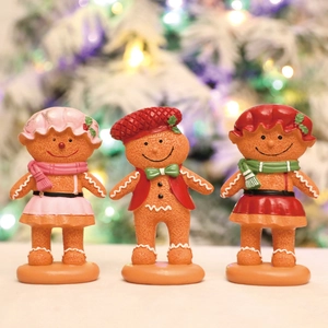 Three-piece gingerbread man figurine set for Christmas desktop decor with warm festive lighting
