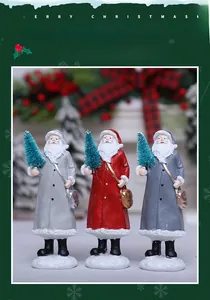 Detailed view of three resin Santa Claus figurines with miniature trees in festive colors