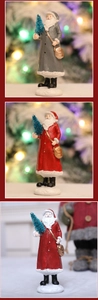 Detail of handcrafted Santa Claus resin ornaments with sparkling mini trees and snow base