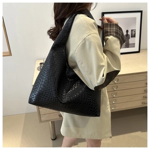Détail du grand sac hobo tressé noir en cuir avec une texture artisanale de qualité