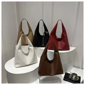 Détail de sacs hobo tissés en cinq couleurs sur un support au style minimaliste