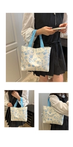 Detail of canvas tote bag featuring blue graffiti bear print and durable woven handles