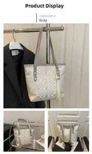 Detailed view of gray geometric tote bag with elegant tassel and leather handles