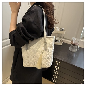 Dettaglio della borsa tote jacquard bianca con motivi floreali e nappa in seta