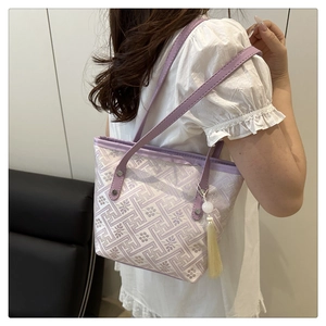 Dettaglio di ricami viola con nappe su una borsa a secchiello in stile neo-cinese