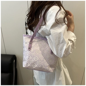 Dettaglio della borsa a secchiello jacquard ricamata viola con manico in pelle e rivetti