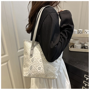 Modella che indossa una borsa tote beige stile New Chinese con ricamo tradizionale fret