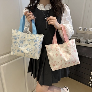 Graffiti canvas tote bag in light blue and pink handles shown in a home setting