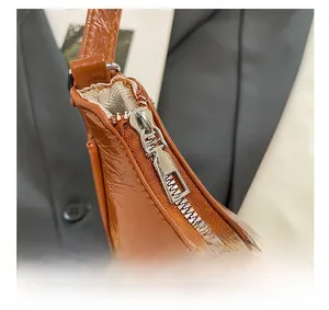 Détails de la fermeture éclair argentée sur un sac à main en cuir marron brillant