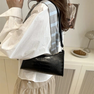 Classic black crocodile pattern baguette bag for women shown in a warm lifestyle setting