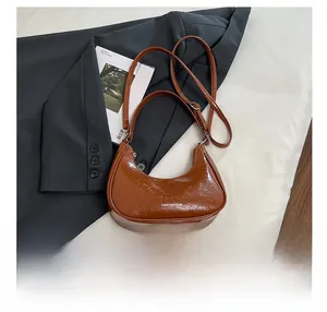 Détail du sac à main marron effet froissé avec fermeture éclair et fine bandoulière réglable