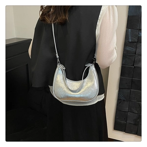 Sac hobo en cuir argenté froissé porté en bandoulière sur mannequin avec forme demi-lune