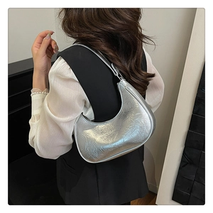 Détail du sac hobo argenté montrant la silhouette en croissant et la texture effet cuir