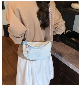 Detail of light blue nylon crescent bag with embroidery and checkered shoulder strap