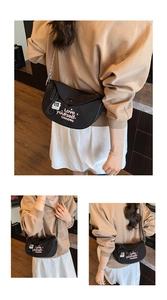 Detail of black crescent shoulder bag with Love Yourself embroidery and metal chain strap