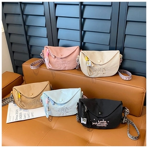 Collection of retro saddle bags in five colors with woven straps on a leather bench