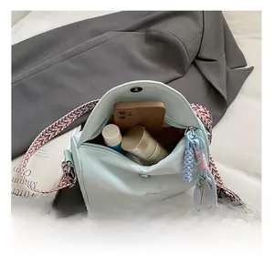 Detail view of mint blue saddle bag showing interior capacity for phone and cosmetics