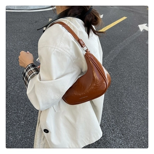 Détails du sac demi-lune plissé marron caramel sur chemise blanche à l'extérieur