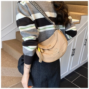 Detail of beige half-moon crossbody bag with Love Yourself embossing and woven strap