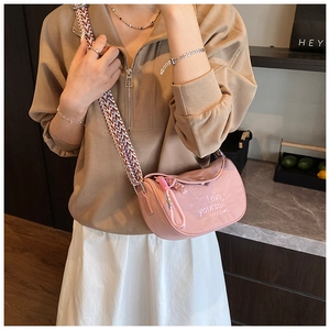 Detail of pink half-moon crossbody bag with embroidered slogan and wide geometric strap