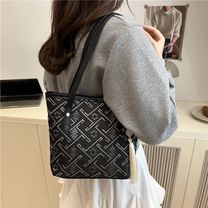 Borsa a secchiello ricamata in stile cinese moderno nera con motivi geometrici e nappa bianca