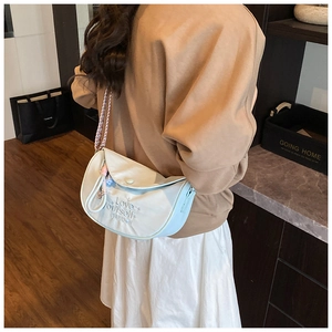 Detail of half-moon shoulder bag with Love Yourself embroidery and woven strap