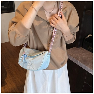 Detail of light blue crossbody bag with geometric woven strap and Love yourself embroidery