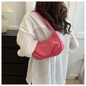 Détail du sac sous le bras plissé rose avec texture brillante et logo ovale