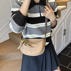 Beige saddle bag with embroidery, fringe detail and woven strap in a casual crossbody style