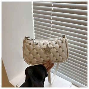 Close-up of quilted cream handbag featuring sparkling rhinestones and a star emblem detail