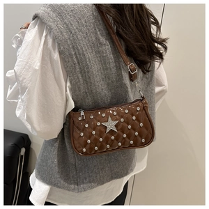 Detail of brown patent leather underarm bag with star motif and studded rhinestones