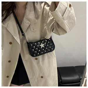 Detail of black quilted patent leather bag with rhinestone stars and silver star charm
