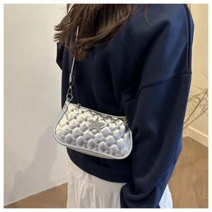 Detail of silver quilted crossbody bag featuring a sparkling rhinestone star motif