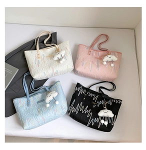 Close-up of four canvas tote bags with wave embroidery and cute cloud plush charms