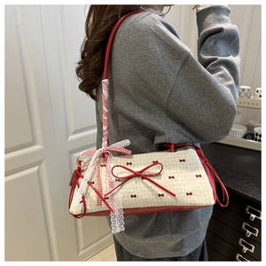 Detail of red bow print shoulder bag with 3D ribbon and lace strap accents
