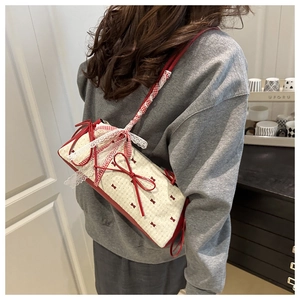 Detail of red and white crossbody bag with silk bow and elegant lace trim decorations