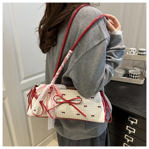Close-up of a sweet red bow underarm bag with polka dot canvas and lace details