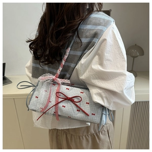 Detail of sweet blue plaid shoulder bag with lace trim and red bow patterns on a model