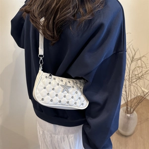 White quilted crossbody bag with sparkling rhinestones and star emblem shown on model