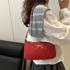 Red lychee pattern shoulder bag with golden bow clasp and floral zipper pull charm