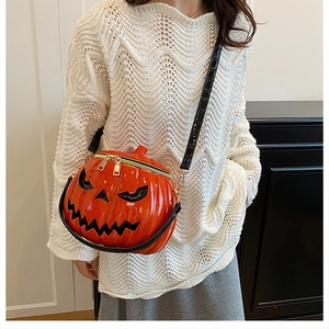 Macro view of bright orange pumpkin bag with 3D Jack O' Lantern face and gold zippers