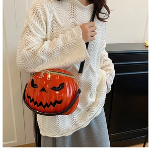 Detail of pumpkin-shaped Halloween crossbody bag with facial relief and double zippers