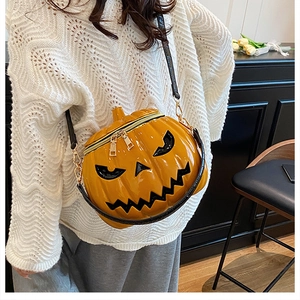 Detail of 3D pumpkin shoulder bag with glossy orange finish and black devil face print