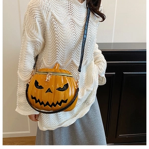 Detail of pumpkin crossbody bag with black face expression and embossed crocodile strap