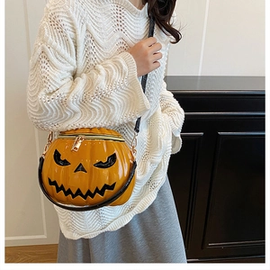 Close-up of Jack-o'-lantern pumpkin crossbody bag with gold zipper and black strap