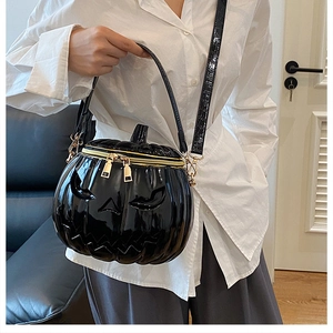 Detail of the 3D pumpkin shoulder bag in black patent leather with golden double zippers