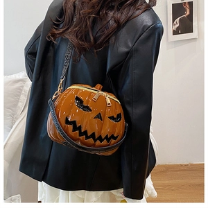Detail of pumpkin crossbody bag with black crocodile texture strap and glossy finish